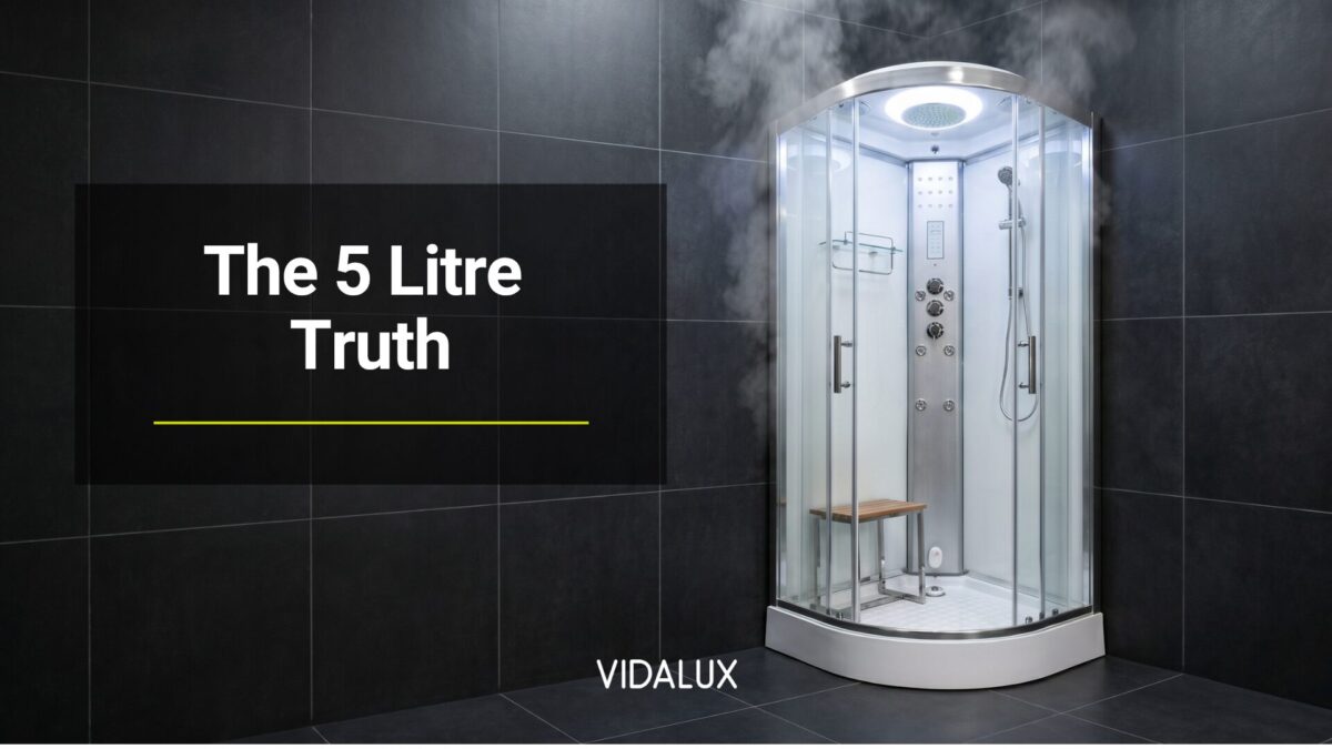 A white Vidalux SS90 quadrant steam shower cabin installed in the corner of a dark-tiled modern bathroom, with soft steam rising from the top of the enclosure.