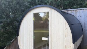 A Vidalux barrel sauna installed on garden decking with clearance around it
