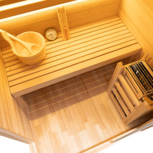Inside the Vidalux Klassikko traditional sauna with cedar bench, wooden bucket and ladle, and stone-filled heater