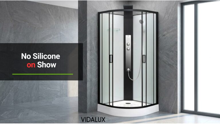 Vidalux Kontrast 800 Square shower cabin with black frame and white glass panels installed in the corner of a grey-tiled bathroom.