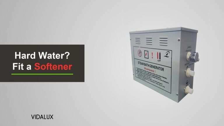 A Vidalux steam room generator, a silver-grey metal box with the steam outlet and water inlet fittings on its side, on a light grey background.