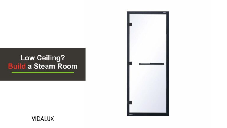 The Vidalux 1860mm by 780mm clear glass steam room door with a black frame, black hinges and a black bar handle, shown against white.