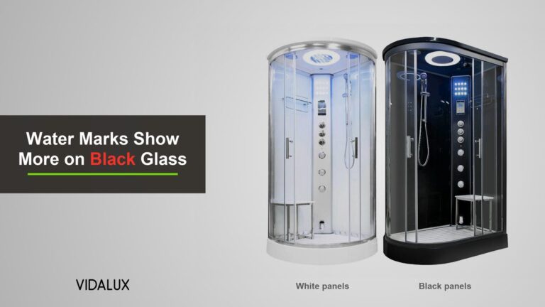 Two Vidalux steam shower cabins side by side, the Essence 1000 with white back panels and the Clearwater 1200 with black back panels, both with clear glass doors on a grey background.